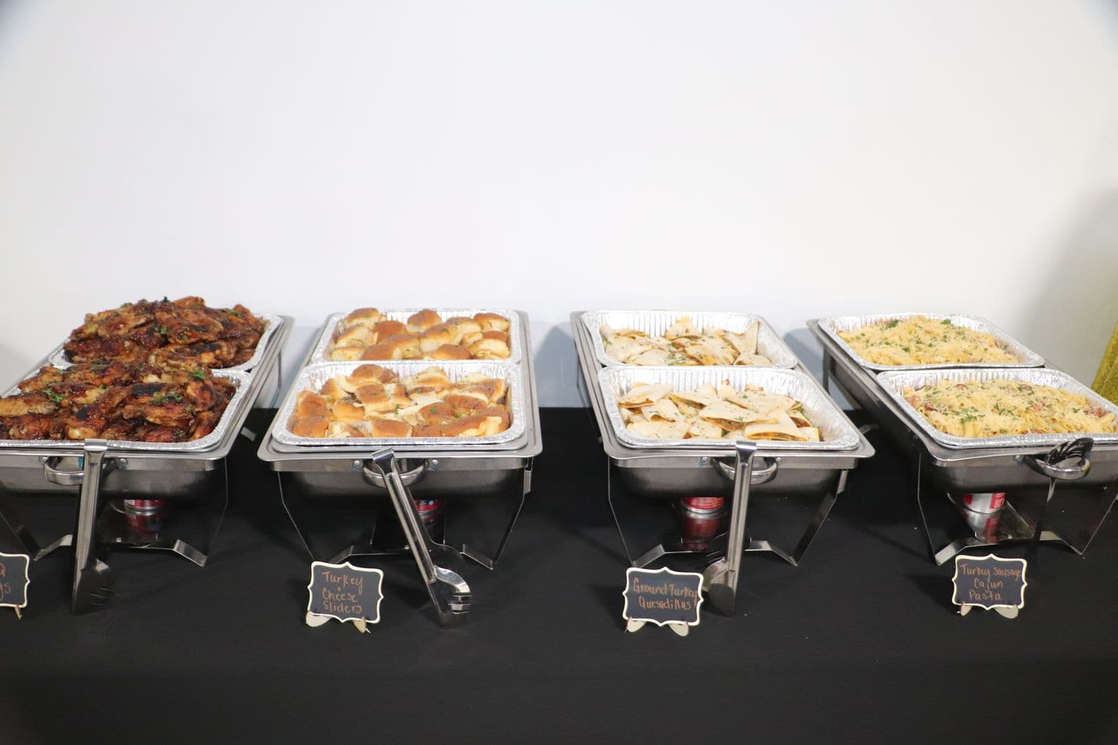Catered chafing dishes labeled along a buffet line